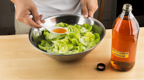 putting apple cider vinegar on salad featured