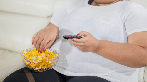 overweight woman with popcorn and tv remote featured