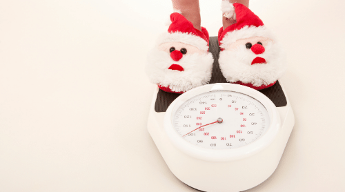 feet with santa slippers on scale featured