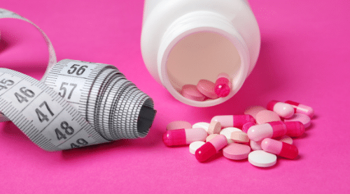 weight loss pills on pink background featured