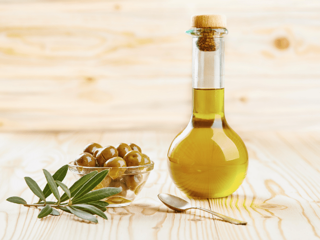 Olive Oil with Olives and Leaves on Table