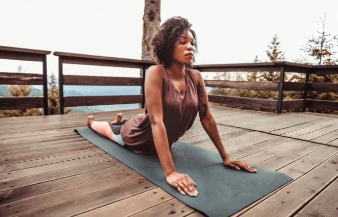 Woman doing cobra yoga pose outside