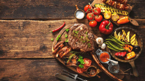 Reclaimed wood table with meat and veggies displayed