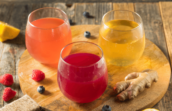 Three glasses filled with different flavors of Kombucha