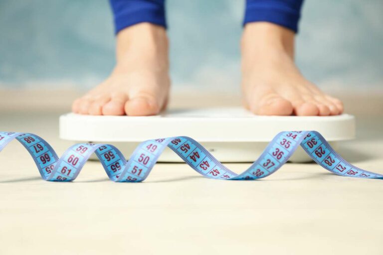 Focus On Fat Loss feet on a scale and a blue measuring tape